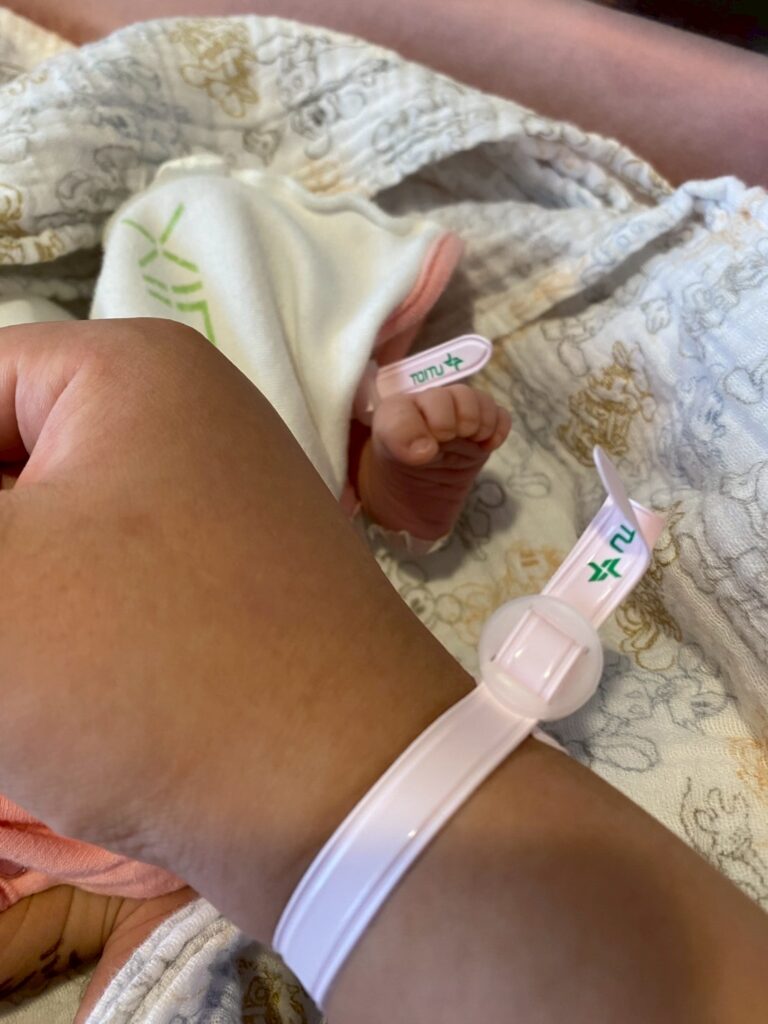 出産後、妻と生まれたばかりの我が子の手が触れ合う写真