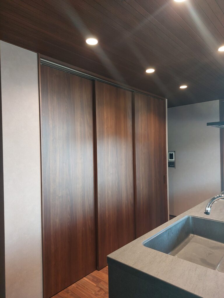 生活感ゼロを実現したキッチンの背面収納：三枚スライド扉を閉じた状態