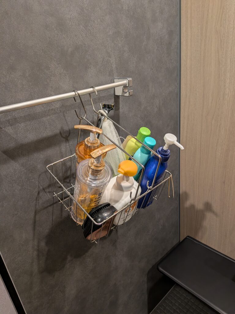 お風呂の棚を削減してシャンプー類を吊るして保存している様子